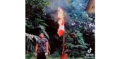 Sambil Merokok Pria Ini Bakar Bendera Merah Putih 