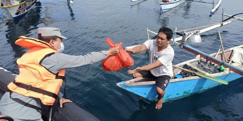 Personel Bakamla RI Bagi-bagi Bansos di Tengah Laut Manado