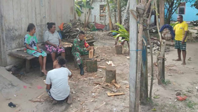 Babinsa Posramil 1708-02/BU-Warsa Bantu Warga Belah Kayu Bakar