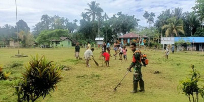 Babinsa Koramil 1708-02/BU Bantu Membabat Rumput di Halaman Rumah Warga Binaan