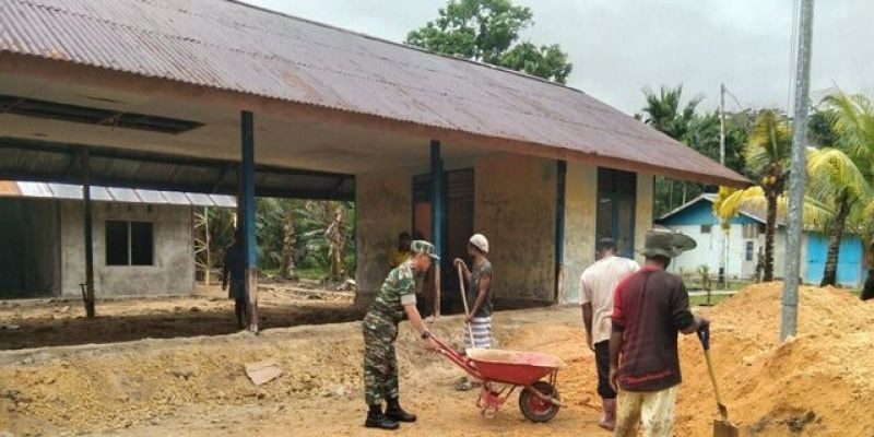 Babinsa Gotong-Royong dengan Warga Timbun Halaman Kantor Balai Desa Kpudori