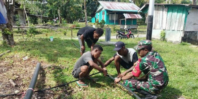 Babinsa Biak Kota Bantu Warga Pasang Saluran Pipa Air Bersih