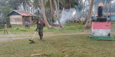 Babinsa Kepulauan Mapia Bantu Warga Bersihkan Halaman Pustu dan Kantor Desa
