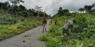 Kompak Bersama Warga, Babinsa Ikut Gotong-Royong Bersihkan Jalan di Kampung Wouna