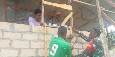 Babinsa Biak Kota Bantu Warga Binaannya Memasang Kusen Jendela Rumah