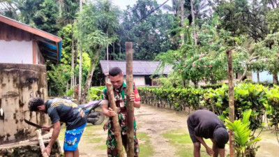 Babinsa Numfor Bantu Warga Kampung Saribi Mendirikan Tiang Jemuran Pakaian