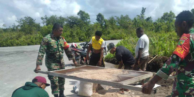 Babinsa Posramil Biak Timur Bantu Mahasiswa KKN Pembuatan Tugu Batas Kampung