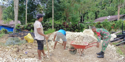 Ringankan Beban Pekerjaan, Babinsa Timbun Pondasi Rumah Warga Kampung Sakobye