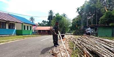 Peduli Kerapian Kampung, Babinsa dan Warga Bersihkan Kayu untuk Buat Pagar