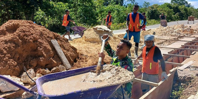 Dukung Pembangunan di Desa Mambesak, Babinsa Bantu Warga Pengecoran  Saluran Air