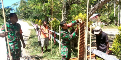 Sambut Natal, Babinsa Bantu Warga Membuat Pagar Rumah di Kampung Warbor