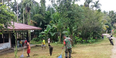 Babinsa dan Warga Gotong-Royong Bersihkan Halaman Kantor Balai Kampung Sopen