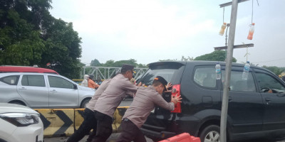 Personel Polsek Cengkareng Berjibaku di Tengah Banjir, Mendorong Mobil Mogok