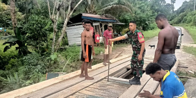 Atasi Kesulitan Warga, Babinsa Bantu Perbaiki Jembatan di Kampung Yenggarbun