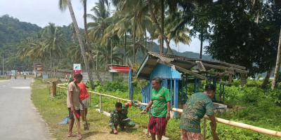 Peduli Kebersihan Lingkungan, Babinsa Bersama Warga Bersihkan Rumput di Bahu Jalan Kampung Amoy
