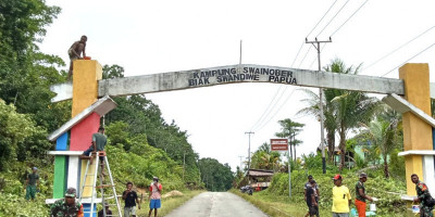 Manunggal dengan Rakyat, Babinsa Biak Barat Bantu Pengecatan Gapura