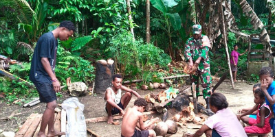 Sambangi Warga Binaan Kampung Amoi, Babinsa Bantu Kupas Kelapa
