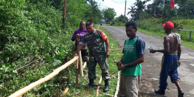 Demi Kenyamanan Pengguna Jalan, Babinsa Biak Barat Bantu Warga Buat Pagar Jalan