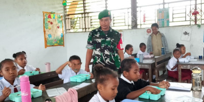 Babinsa Biak Timur Dampingi Penyaluran Makanan Bergizi Gratis Anak Sekolah