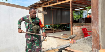 Babinsa Biak Kota Bantu Warga Plester Dinding Rumah