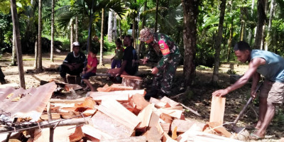 Ringankan Pekerjaan, Babinsa Numfor Bantu Warga Belah Kayu Bakar