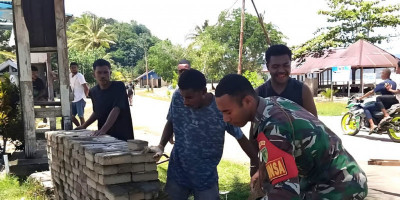 Semangat Gotong-Royong, Babinsa Supiori Utara Bantu Warga Rapikan Paving Block