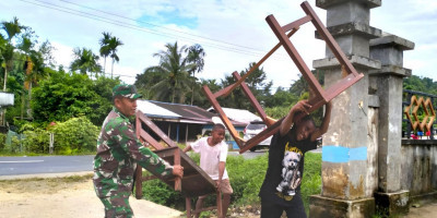 Usai Diperbaiki, Babinsa dan Siswa SMP YPK Korido Angkat Meja Belajar ke Ruang Sekolah