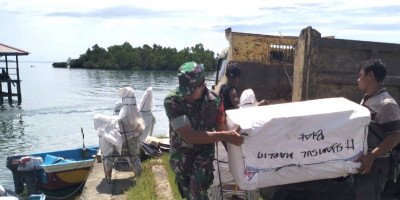 Babinsa Supiori Selatan Bantu Warga Angkut Perlengkapan Puskesmas Kepulauan Aruri