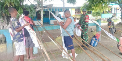 Babinsa Bantu Warga Pasang Umbul-Umbul Sambut HUT Jemaat dan Paskah